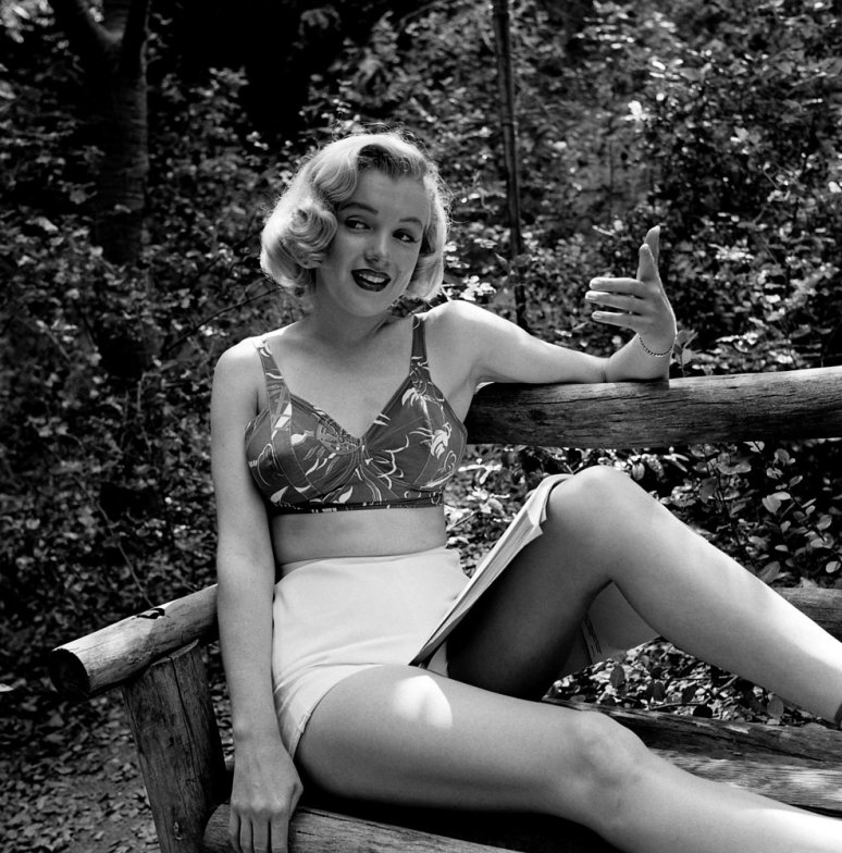 Fotografía de Marilyn monroe leyendo en el bosque