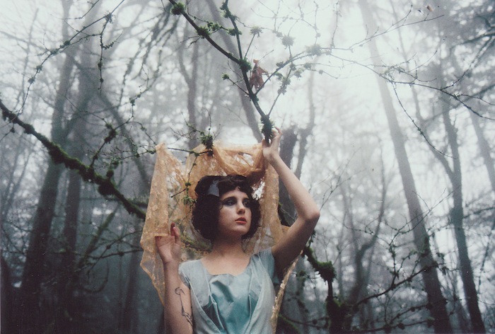 Mujer modelo posando con una traje de fantasi en un bosque