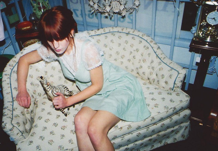 Chica sentada con un vestido corto y con un muñeco de una cebra, fotografia de Hana Haley