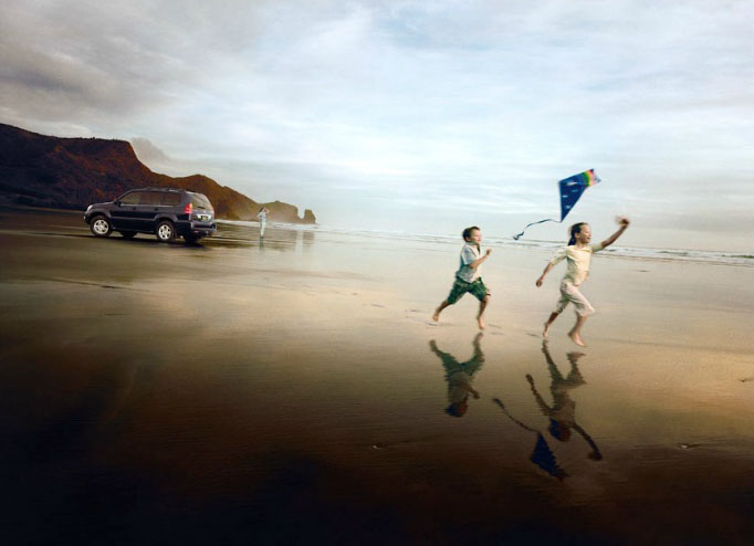 Foto de niños corriendo por la playa volando una cometa