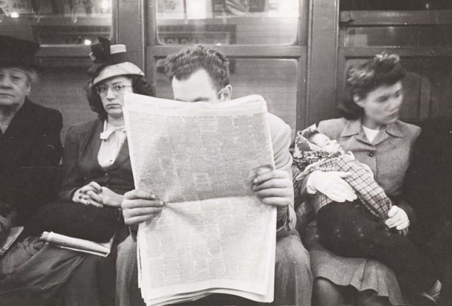 Hombre leyendo periodico sentado en el metro