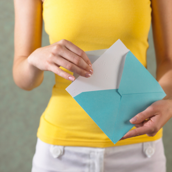 Fotografía de una mujer sacando una carta de un sobre de papel