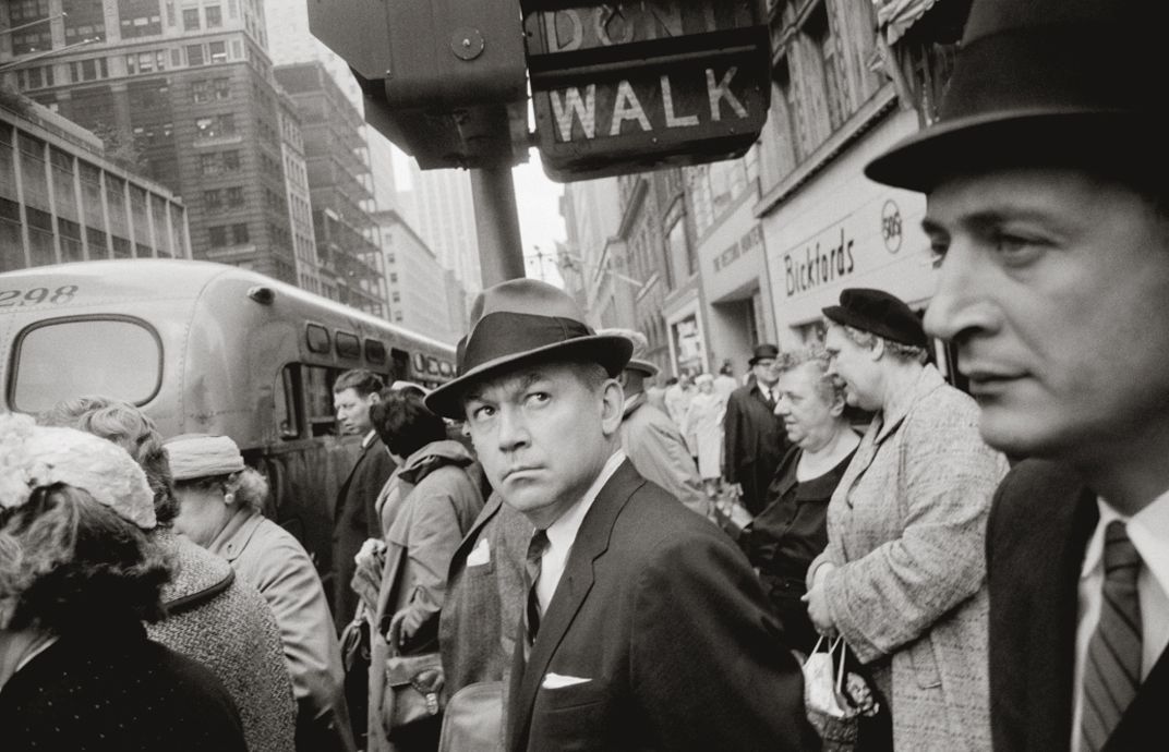 Hombre junto a semaforo en una calle de nueva york