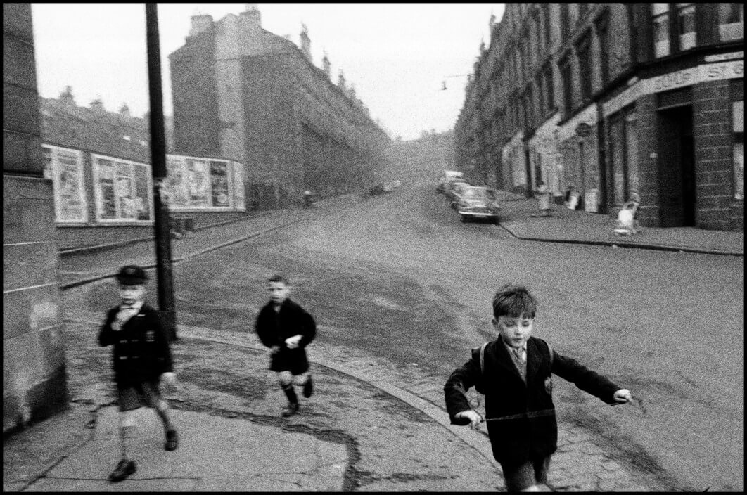 UK. 1960. Three boys running in streets.