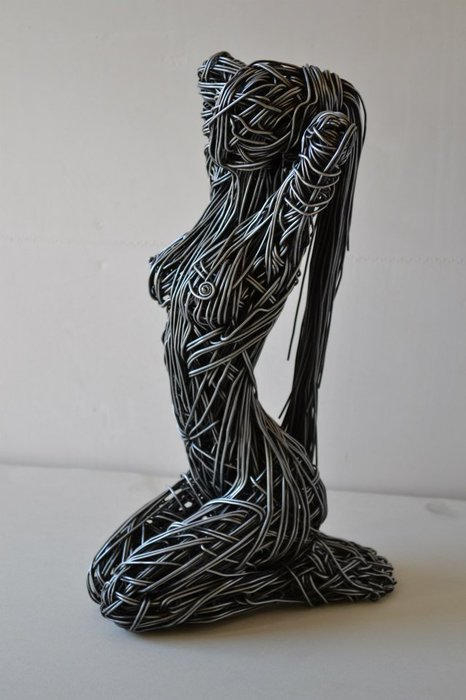 Escultura de alambre creada por Richard Stainthorp de una mujer recogiéndose el pelo 