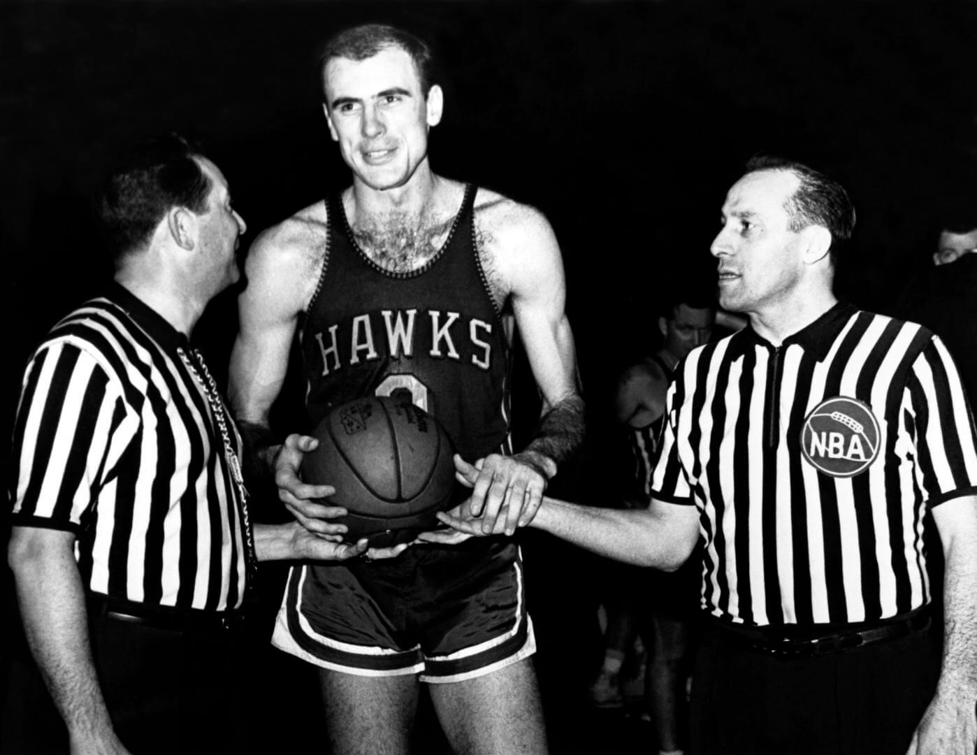 1955: Bob Pettit #9 of the St. Louis Hawks poses for a portrait with referees circa 1955. NOTE TO USER: User expressly acknowledges and agrees that, by downloading and/or using this Photograph, user is consenting to the terms and conditions of the Getty Images License Agreement. Mandatory Copyright Notice: Copyright 1955 NBAE (Photo by NBA Photos/NBAE via Getty Images)