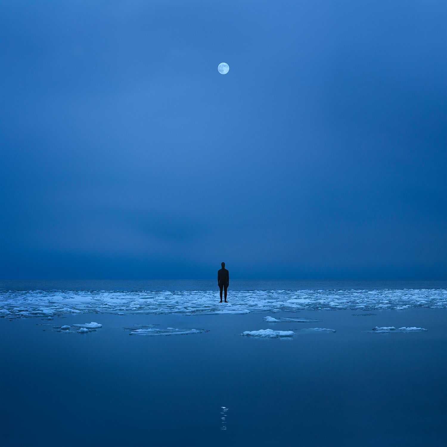 fotografía surrealista de hombre en mitad del mar con la luna al fondo