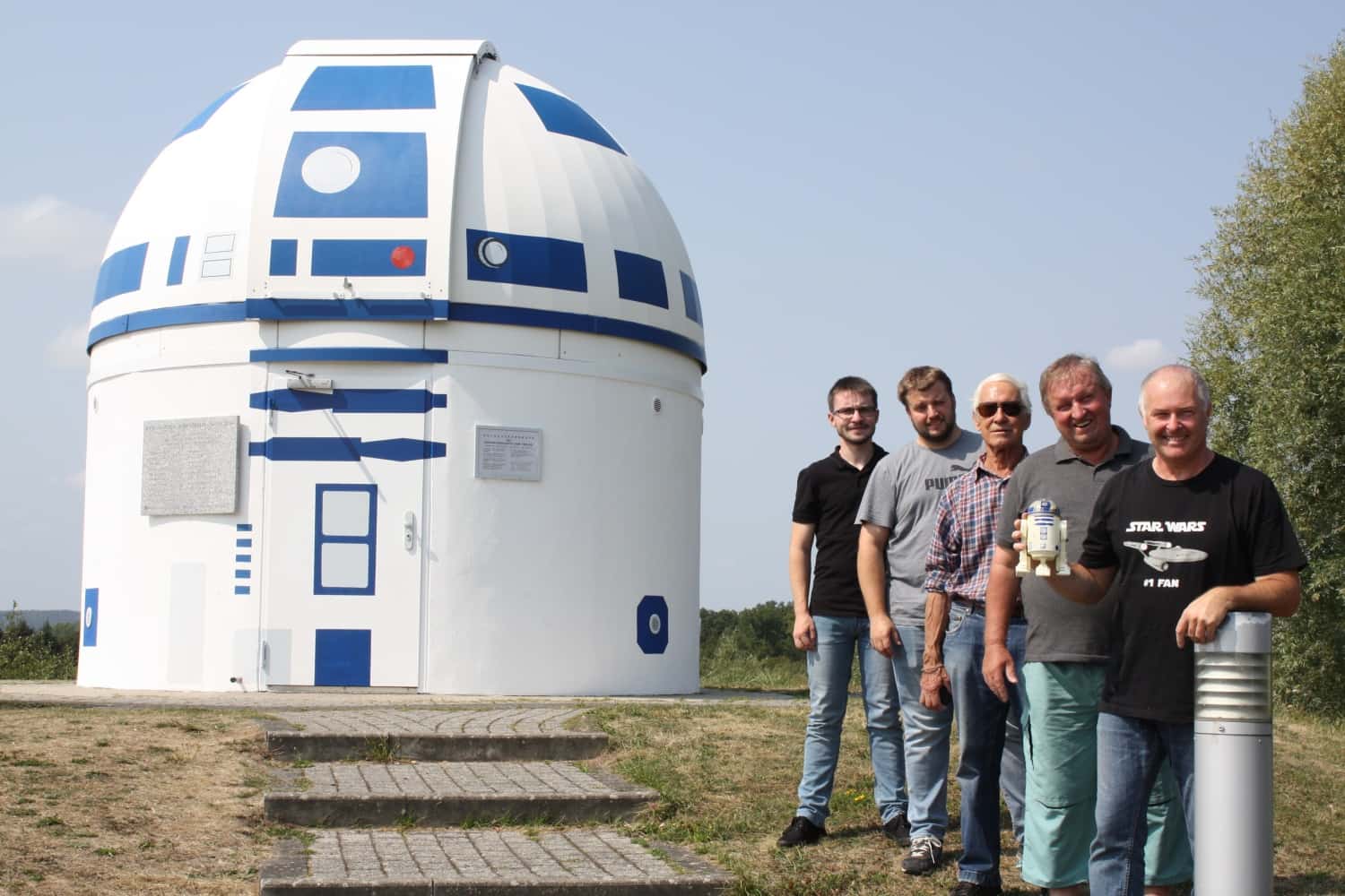 Cientificos en la puerta del observatorio de Zweibrücken como si fuera el androide r2d2