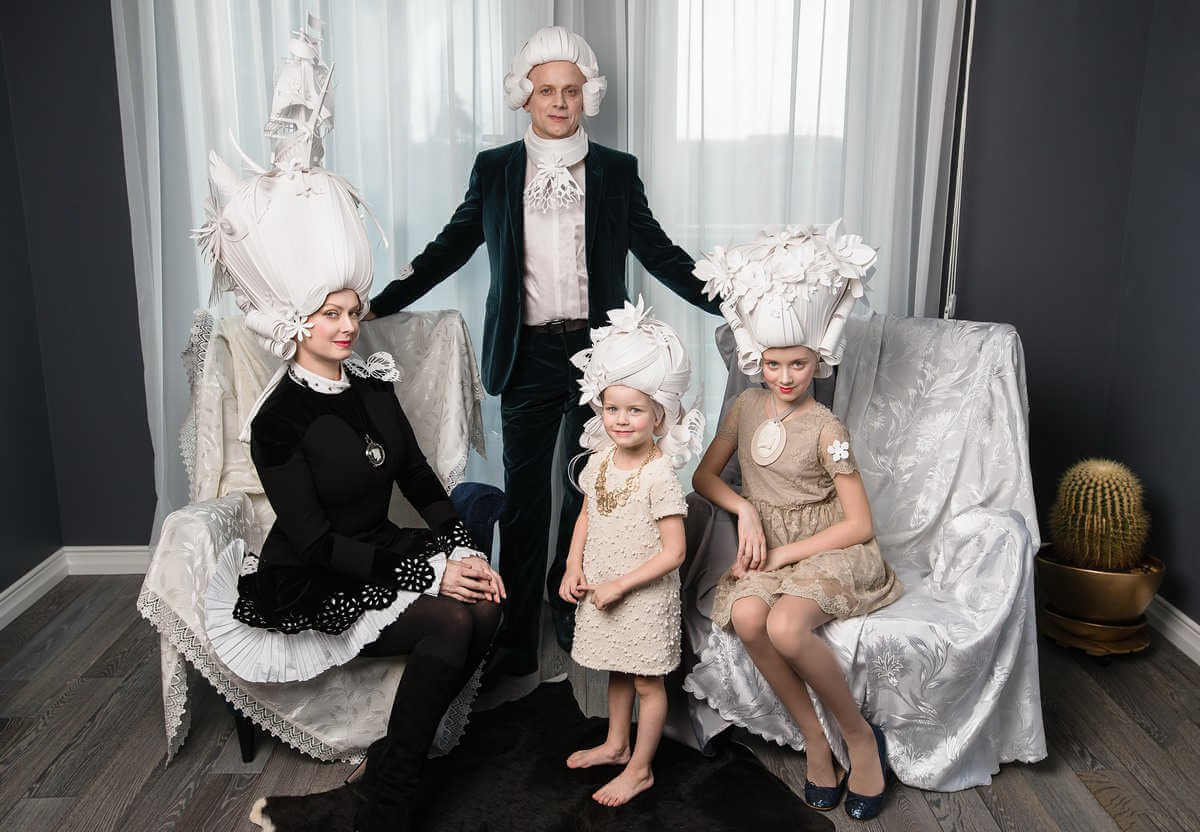 Familia posando con pelucas hechas de papel de estilo barroco