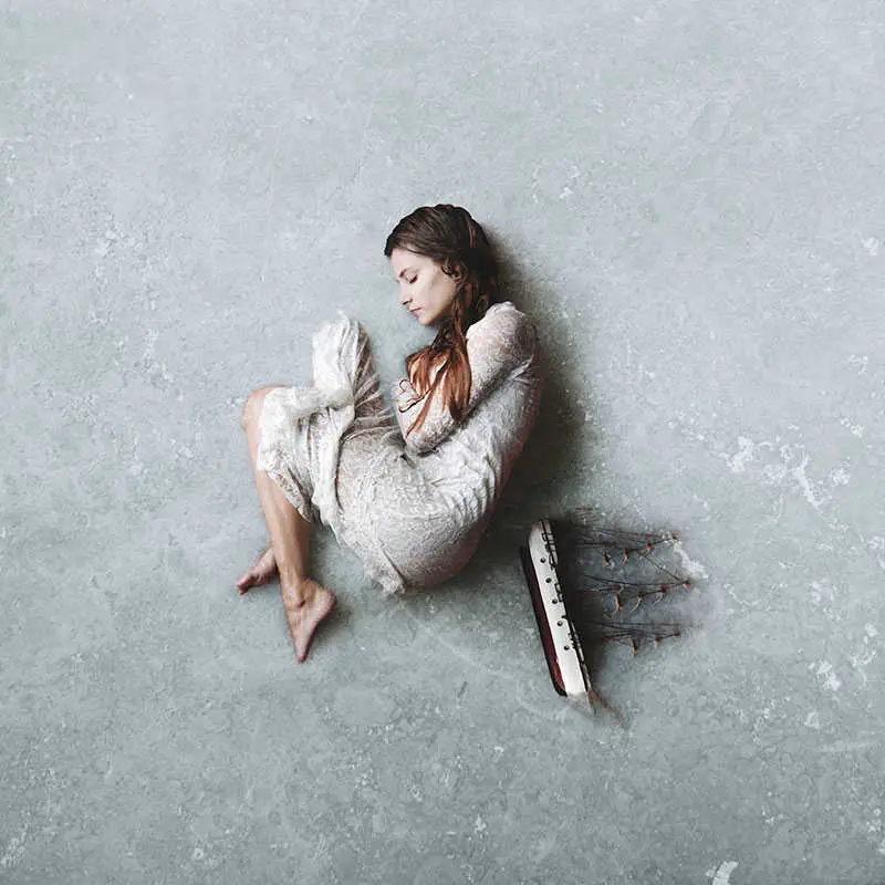 Fotografía de una mujer tumbada en el hielo junto a un barco, hecha por frank diamond