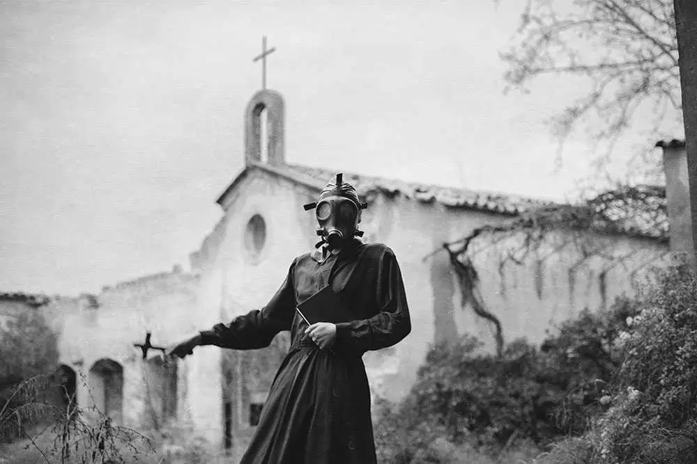 fotografía de mujer con mascara de gas frente una iglesia