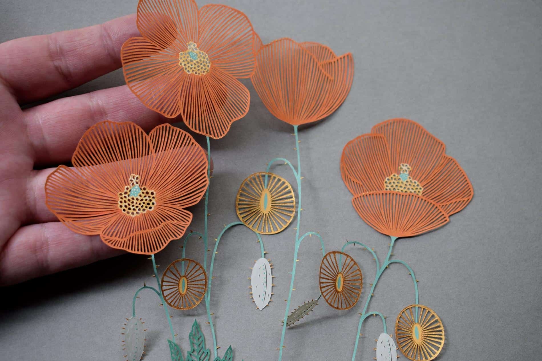 detalle de flores naranjas hechas a ano en papel cortado minuciosamente por pippa dyrlaga