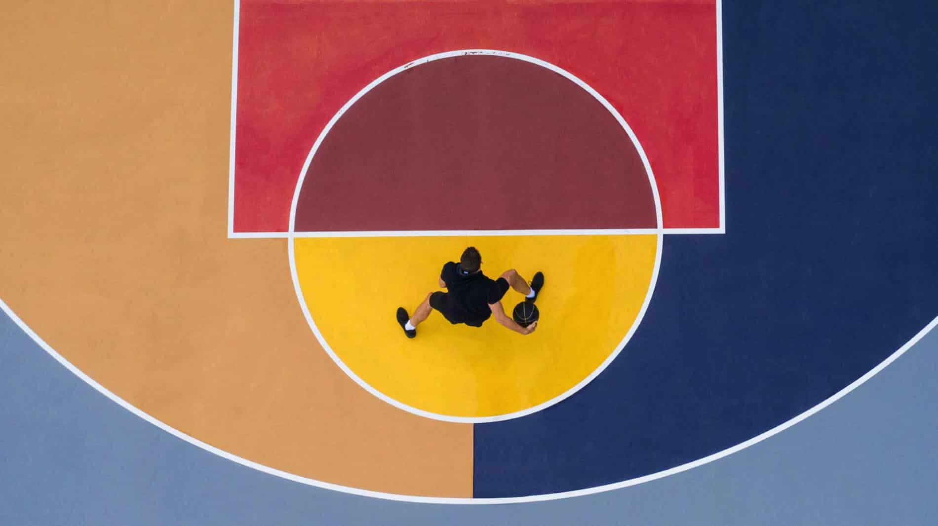 fotografia aerea de persona jugando baloncesto sobre fopndo de colores por Ilanna Barkusky