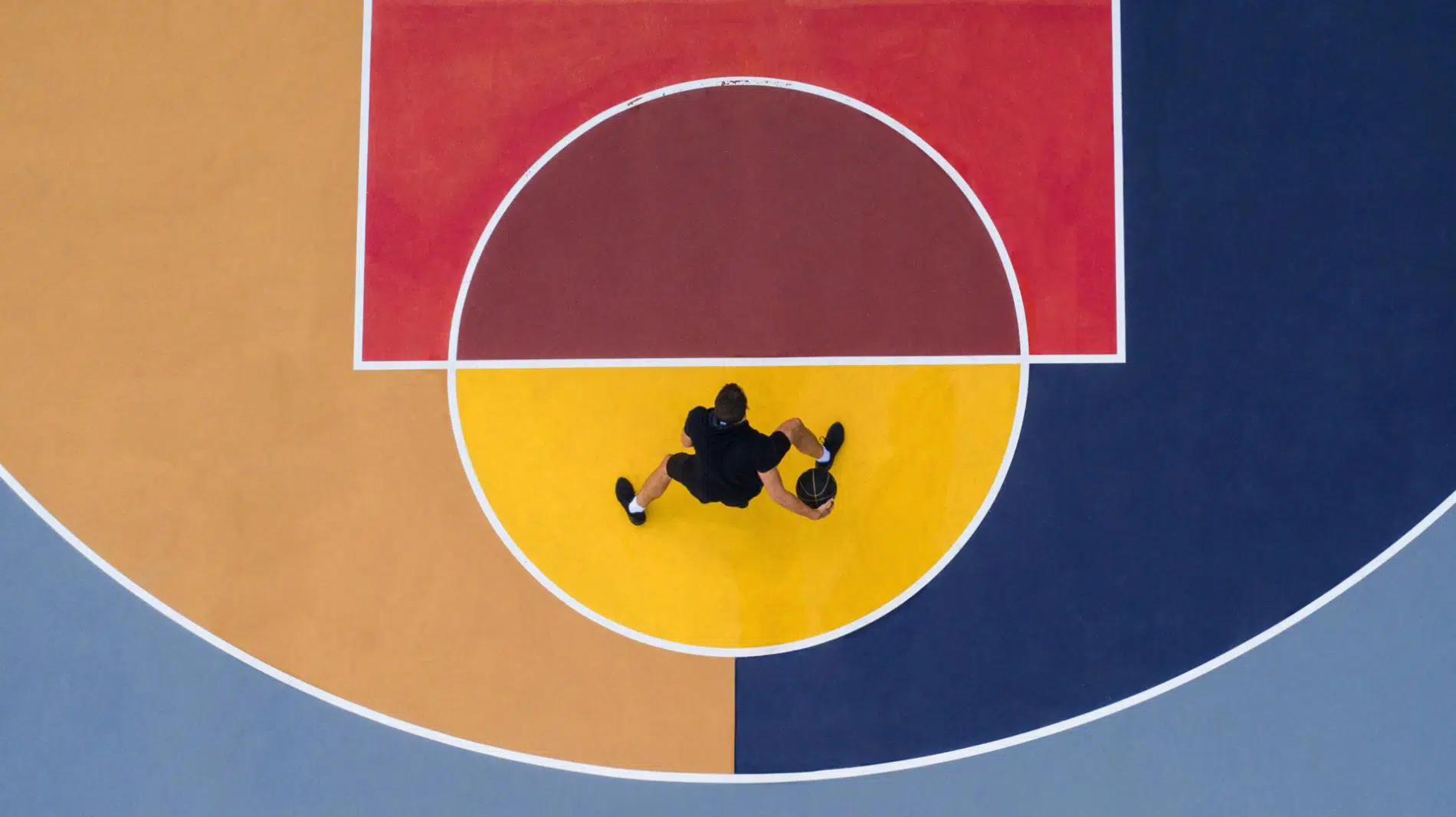 fotografia aerea de persona jugando baloncesto sobre fopndo de colores por Ilanna Barkusky