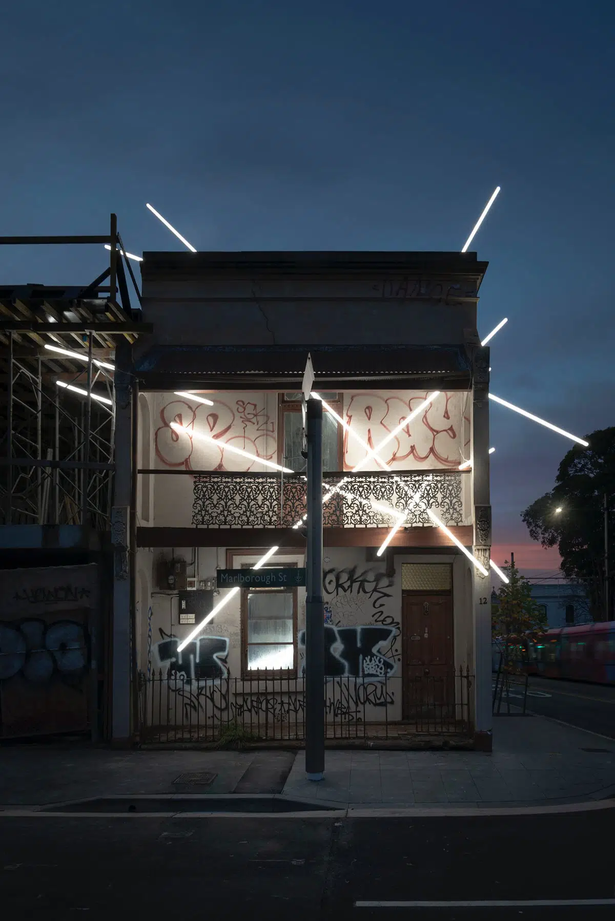 Ian Strange casa iluminada intervencion arquitectonica vista frontal con graffitis